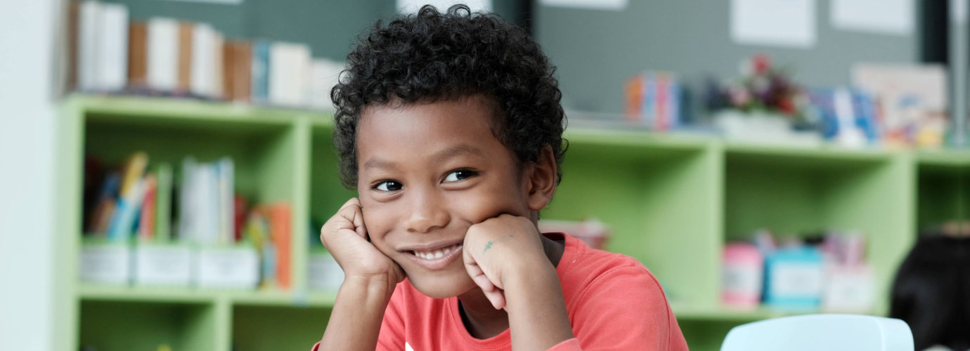 young boy smiling in a class room